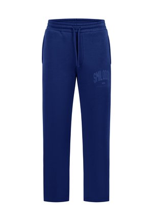 Pantalon de survêtement bleu marine avec taille élastique, cordon, poches latérales et détail textuel subtil sur la partie supérieure de la jambe gauche.