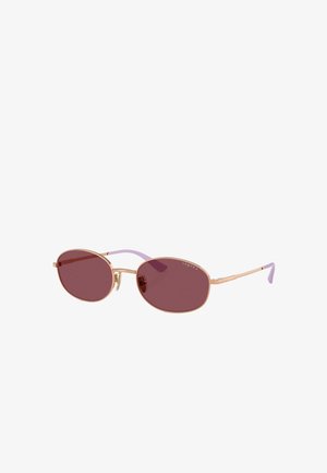 Occhiali da sole ovali con lenti di un oscuro bordeaux, montatura in metallo rosa oro e aste di un leggero viola. Dotati di naselli regolabili.