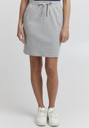 Jupe en jersey de coton gris avec une taille élastique à cordon, longueur genoux, texture lisse, assortie à des baskets blanches.