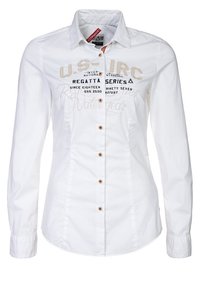 Biała koszula z długim rękawem, zapięcie na guziki z przodu, haftowany tekst w ciemnoniebieskim i beżowym kolorze oraz brązowe guziki jako akcenty. Gładka faktura tkaniny.