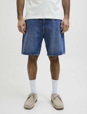 Shorts en denim avec une coupe décontractée, de couleur bleu clair et un ourlet effiloché. Assortis avec des chaussettes blanches et des chaussures beiges pour le contraste.