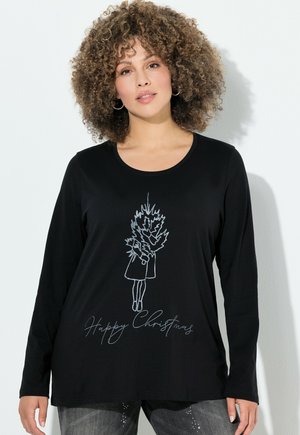 Maglietta nera a maniche lunghe con un grafico a contorno bianco che rappresenta una ragazza che tiene un albero di Natale e il testo "Buon Natale" sotto.