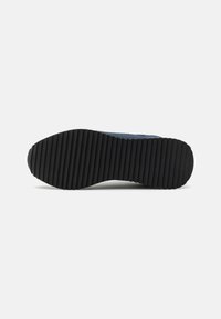 Rubber footwear sole with a textured, ribbed surface; dark gray color; designed for traction and durability.