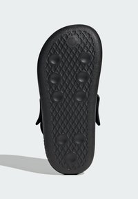 Black rubber sandal sole featuring a textured surface with a diamond pattern and six circular raised dots for grip and traction.