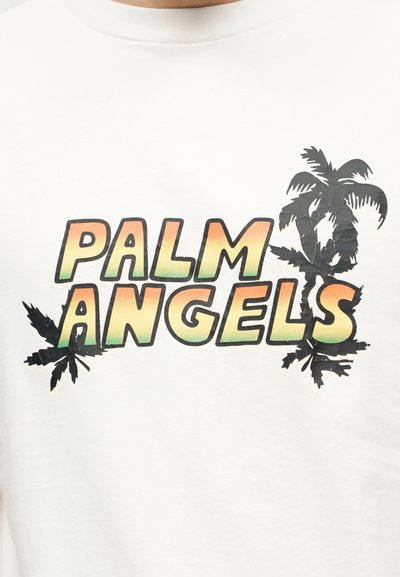 Λευκό πουκάμισο με το κείμενο "PALM ANGELS" σε διαβάθμιση πορτοκαλί-πράσινο, συνοδευόμενο από μαύρα γραφικά φοινικόδεντρων γύρω από τα γράμματα.
