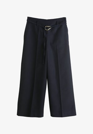 Granatowe spodnie o szerokich nogawkach z paskiem do wiązania, ozdobione złocistą owalną klamrą, plisami oraz gładką, lekką fakturą tkaniny.