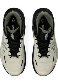 Buty sportowe ASICS w jasnobeżowym i czarnym kolorze, z fakturowanym wierzchem, z zapięciem na sznurówki oraz oznaczeniem Gore-Tex. Czerwone akcenty na podeszwie.