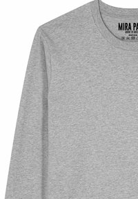 Maglietta grigia a maniche lunghe realizzata in morbido cotone biologico. Presenta una scollatura tonda e testo dell'etichetta stampato sul collo.