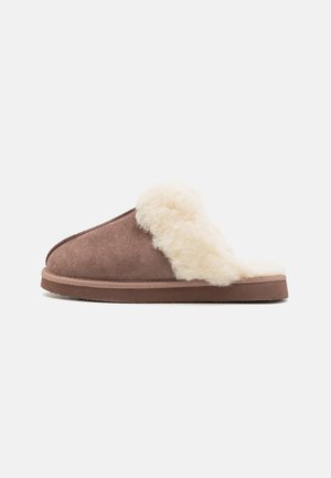 Brown suede slipper with a fluffy cream faux fur lining, open back design, and a flat rubber sole, showcasing a soft texture and cozy appearance.