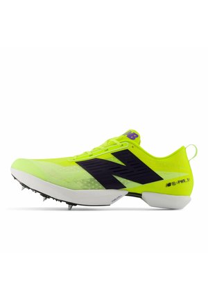 Neongule New Balance banesko med sort logo, hvid sål med metalsåler og let mesh overdel.