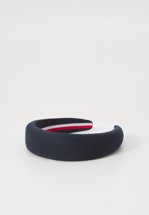 Navy fabric headband with a smooth texture, featuring a white section and red and white stripes on the inner lining.