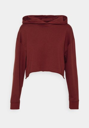 Bordeauxrotes, verkürztes Hoodie mit langen Ärmeln, abgesenkten Schultern und lockerem Schnitt, auf einem einfarbigen hellgrauen Hintergrund präsentiert.