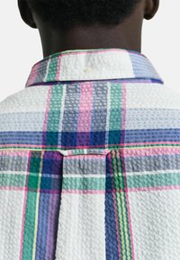 Camisa con cuello que presenta un patrón de cuadros multicolores en tonos blanco, rosa, verde, azul y púrpura; tejido texturizado y un pliegue en la parte posterior.