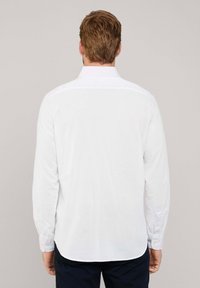 Wit overhemd met lange mouwen van katoen, met een standaard kraag, knopenmanchetten en een afgeronde zoom. Geen patronen of accenten zichtbaar.