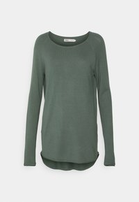 Grüner Pullover mit langen Ärmeln, rundem Ausschnitt, weicher Textur, gerippten Bündchen, geschwungenem Saum und minimalen Nahtdetails.