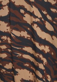 Tessuto a stampa animale con una base beige e strisce marroni scure e nere. La texture appare liscia con una leggera lucentezza.