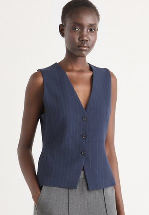 Middagblauwe mouwloze vest, met een diepe V-halslijn, vijf knopen en subtiele streepjes. Gladde stof met een getailleerde pasvorm.