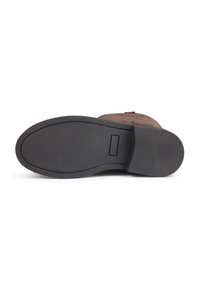 Botte en daim marron avec un bout arrondi, dotée d'une semelle en caoutchouc noir, d'un motif de semelle texturé et d'un talon surélevé pour une meilleure adhérence.