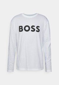 Bílé tričko s dlouhým rukávem vyrobené z bavlny, s odvážným černým potiskem "BOSS" na přední straně. Klasický kulatý výstřih a volný střih.