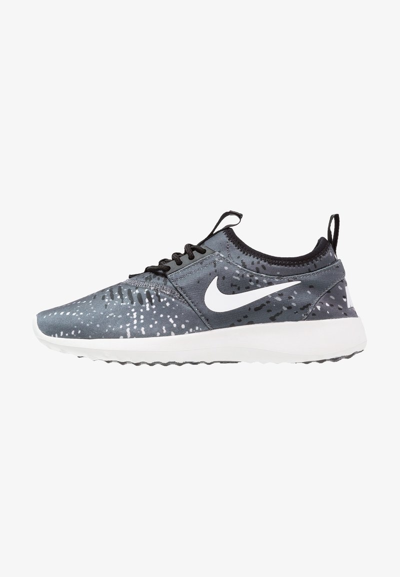 Baskets de sport gris à motif noir avec un logo Nike blanc, des lacets noirs et une semelle blanche, vues de côté extérieur sur un fond blanc.
