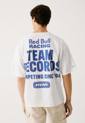 Vit bomull t-shirt med oversized passform, med blåtryckt text på baksidan: "Red Bull Racing TEAM RECORDS, Tävlar sedan '04" samt logo.