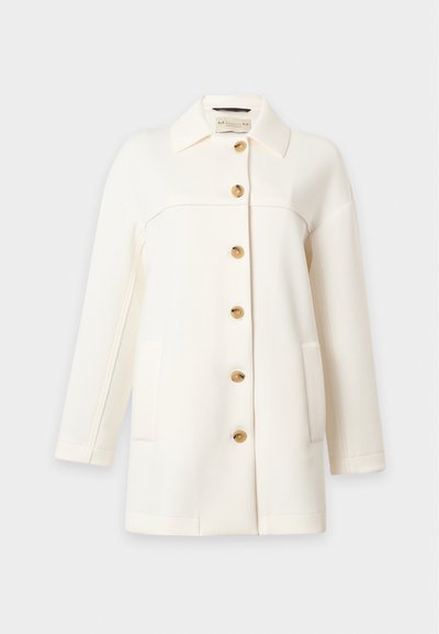 Manteau blanc à manches longues avec col et six boutons marron sur le devant, avec deux poches avant.