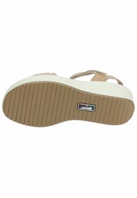 Sandali platform con tomaia sintetica color marrone chiaro e suola intermedia bianca. La suola in gomma presenta scanalature orizzontali per una migliore aderenza.
