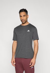 Σκούρο γκρι κοντομάνικη μπλούζα με στρογγυλή λαιμόκοψη και λευκό τριγωνικό λογότυπο στο αριστερό μέρος του στήθους. Υφασμα με απαλή υφή, κλασική εφαρμογή.