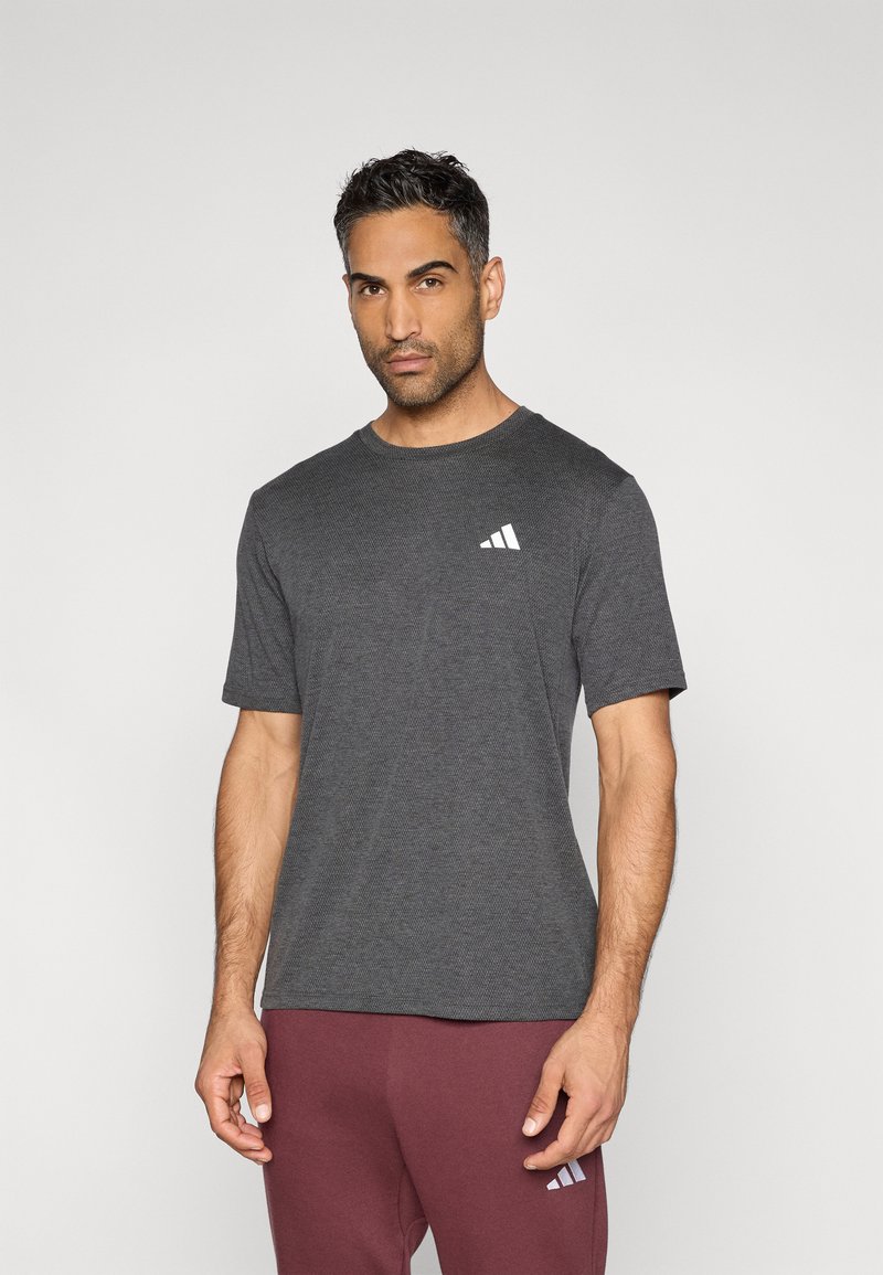 Σκούρο γκρι κοντομάνικη μπλούζα με στρογγυλή λαιμόκοψη και λευκό τριγωνικό λογότυπο στο αριστερό μέρος του στήθους. Υφασμα με απαλή υφή, κλασική εφαρμογή.