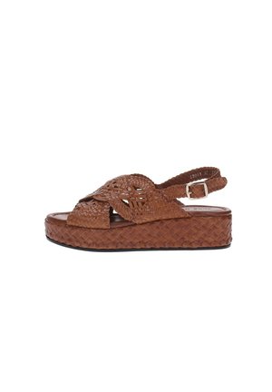 Sandalo platform in pelle intrecciata marrone con cinturini incrociati e chiusura con fibbia regolabile su sfondo bianco.