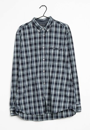 Camicia a maniche lunghe da uomo in tartan blu scuro e azzurro, con chiusura a bottoni, colletto e taschino singolo con orlo curvo. Tessuto di cotone.