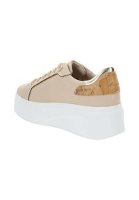 Sneaker beige con tomaia in pelle liscia, dettagli dorati e un distintivo tallone con motivo a mappa. Presenta una suola piattaforma bianca chunky.