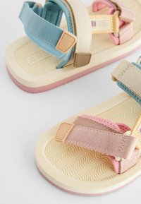 Bunte Kindersandalen mit weichen, strukturierten Gummisohlen; ausgestattet mit verstellbaren Canvas-Riemen in Blau, Beige und Pink sowie strapazierfähigen Verschlüssen.
