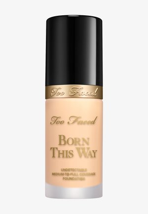 Too Faced Born This Way Foundation in einer mattierten Glasflasche mit schwarzem Deckel. Verziert mit goldenen Schriftzügen und einer weichen beige Produktfarbe.