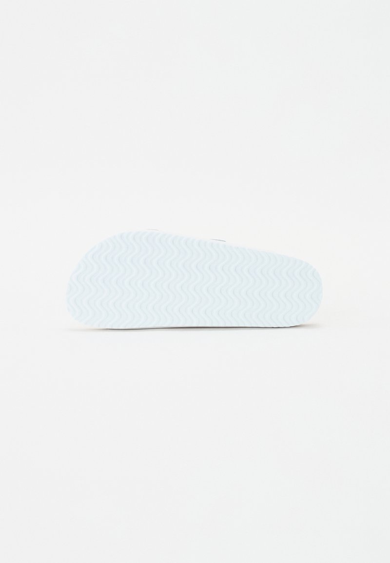 Semelle de chaussure bleu clair avec un motif en zigzag texturé et un bout légèrement arrondi. Fini lisse, conçu pour le confort et l'adhérence.