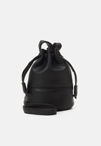 Borsa a secchiello in pelle nera con una texture liscia, cima raccolta e tracolla regolabile. Presenta una base circolare e cuciture sottili.