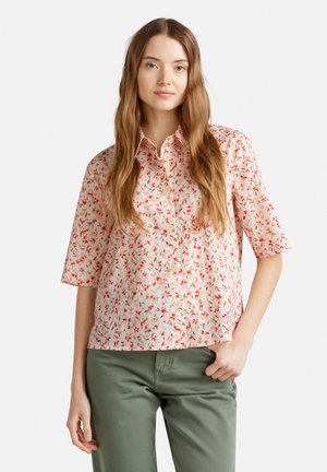 Short-sleeve, button-up shirt in light peach with a floral pattern in red and green. Lightweight fabric with a relaxed fit.