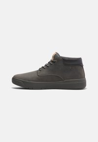 Botas de tobillo de cuero gris oscuro con acentos de cuero negro, punta redonda y cierre de cordones. Presenta un parche de logo en tono marrón y una suela texturizada.