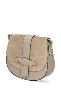 Borsa a tracolla in suede e pelle beige con forma arrotondata, con accenti in metallo dorato e chiusura a pattina. Presenta un bordo scuro a contrasto.