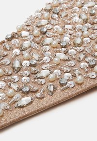 Pochette en sequins avec une base rose gold scintillante ornée de perles en verre, de perles et de diverses formes et textures embellies.