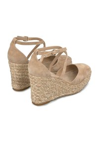 Sandalias de cuña de ante beige con correas de tobillo entrelazadas y una plataforma de yute trenzado. Textura suave y diseño de punta redondeada. Hebilla ajustable.