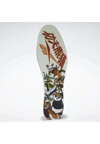 La semelle intérieure présente un design imprimé vibrant avec des animaux de dessin animé et des graphismes, principalement blanche avec des accents colorés et une texture mate.