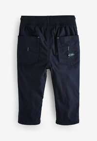 Marineblå cropped bukser med elastisk talje, to baglommer og et vævet mærke. Glat stof uden synlige mønstre.