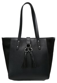 Czarna torba na ramię z teksturowanym materiałem syntetycznym, długimi uchwytami, dekoracyjnymi frędzlami i srebrnymi elementami wykończeniowymi. Charakteryzuje się usztywnionym kształtem.