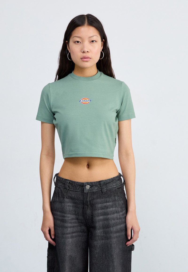 Cropped short-sleeve t-shirt in pale green cotton, featuring a multicolored logo on the chest and a high neckline.