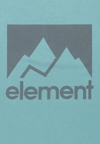 Camiseta de color azul claro con un gráfico de montañas en gris oscuro y la palabra "element" en fuente sans-serif en negrita justo debajo.