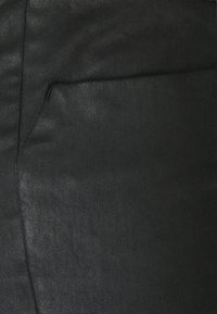 Black fabric with a textured surface, featuring a side pocket and contrasting stitching. Flat and fitted design.