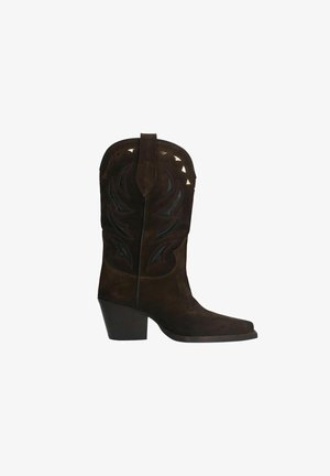 Bruine suède cowboylaars met een puntige neus, decoratieve stiksels en metalen accenten. De hak is van gematigde hoogte, wat stabiliteit biedt.