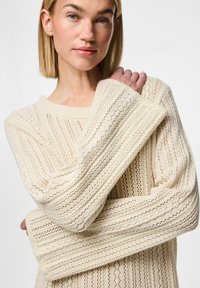 Chunky cremsweater med en lös passform, som har ett strukturerat mönster, breda ribbade ärmslut och en rund halsringning.