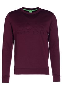Sudadera burdeos con cuello redondo, puños y dobladillo acanalados, con un logo en relieve "BOSS HUGO BOSS" en el frente. Textura suave.